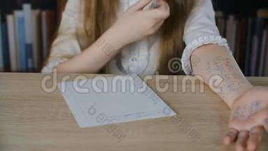女生们手里拿着考试考卷。 学生女生在校考时用作弊单解任务